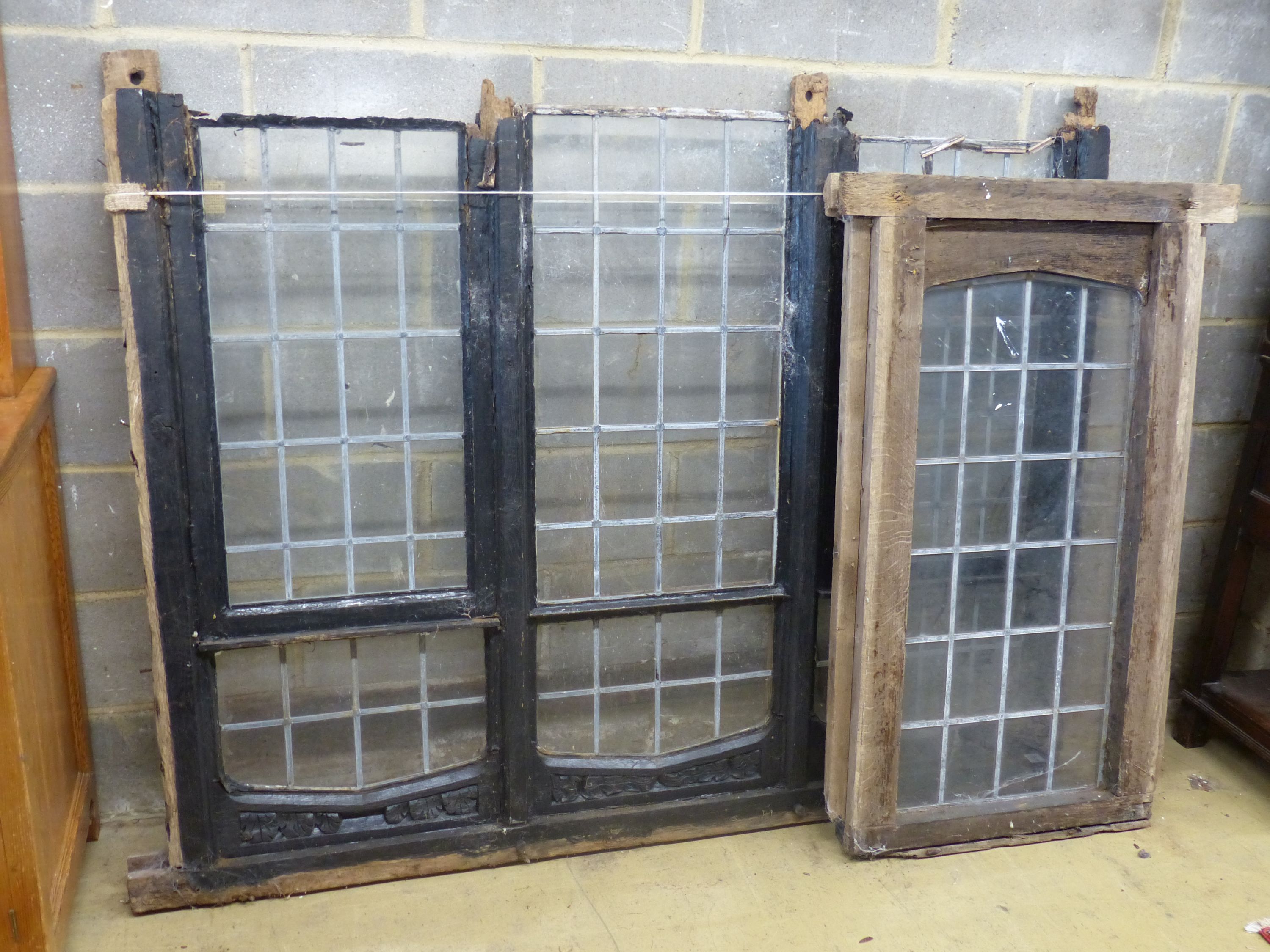 Three old carved oak window frames with leaded lights, largest width 170cm, height 134cm